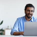 Recruitment Concept. Smiling Western Guy Using Laptop, Searching Jobs Online In Internet